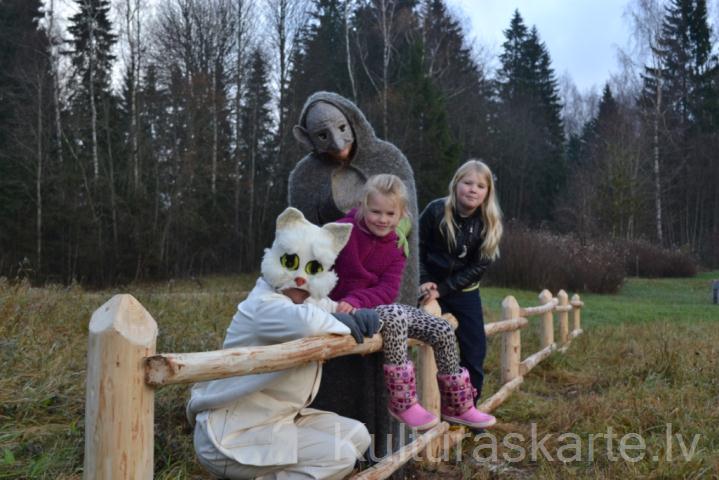 Baltais Kaķītis un Kalna Gars ar bērniem Pasaku pļaviņā pie muzeja.